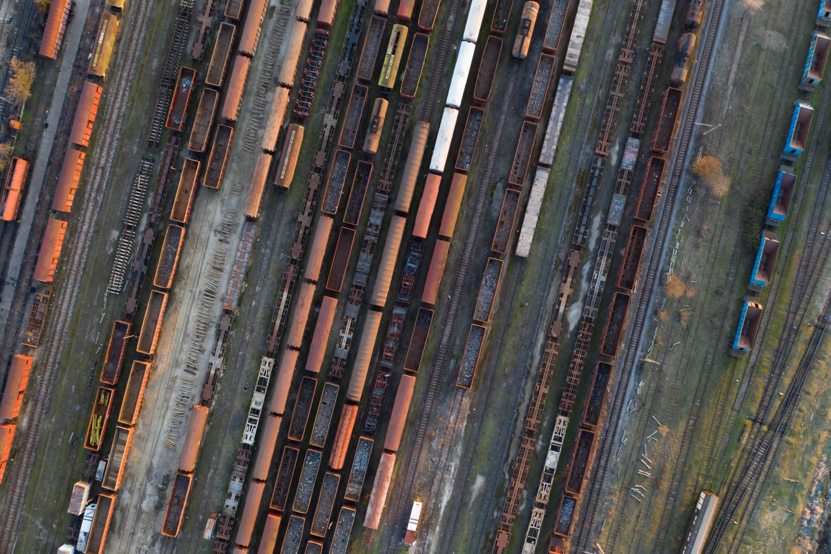 Aerial view of various railway carriage trains with goods on the railway station, top view.